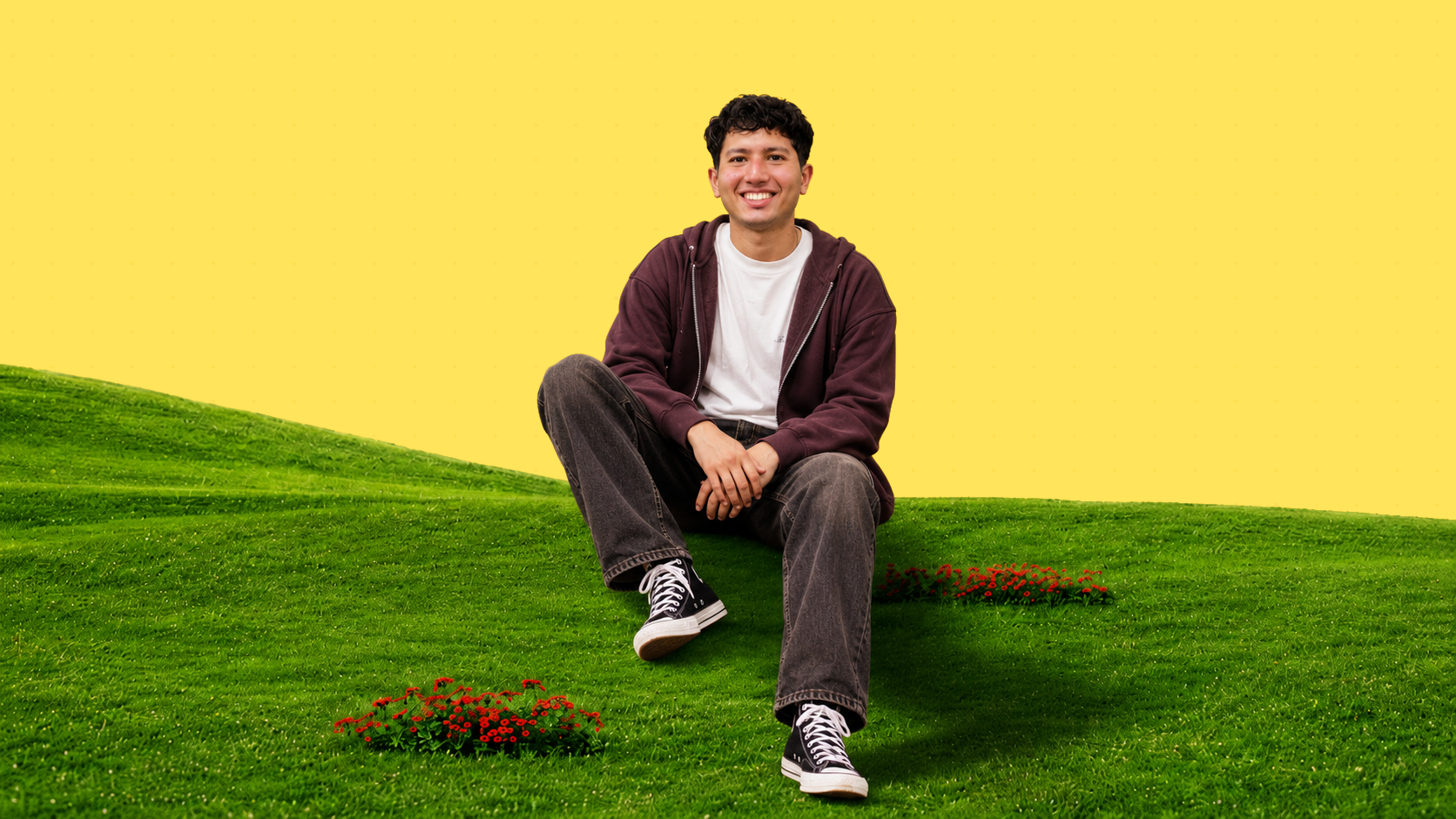 Yash sitting on a grassy hill